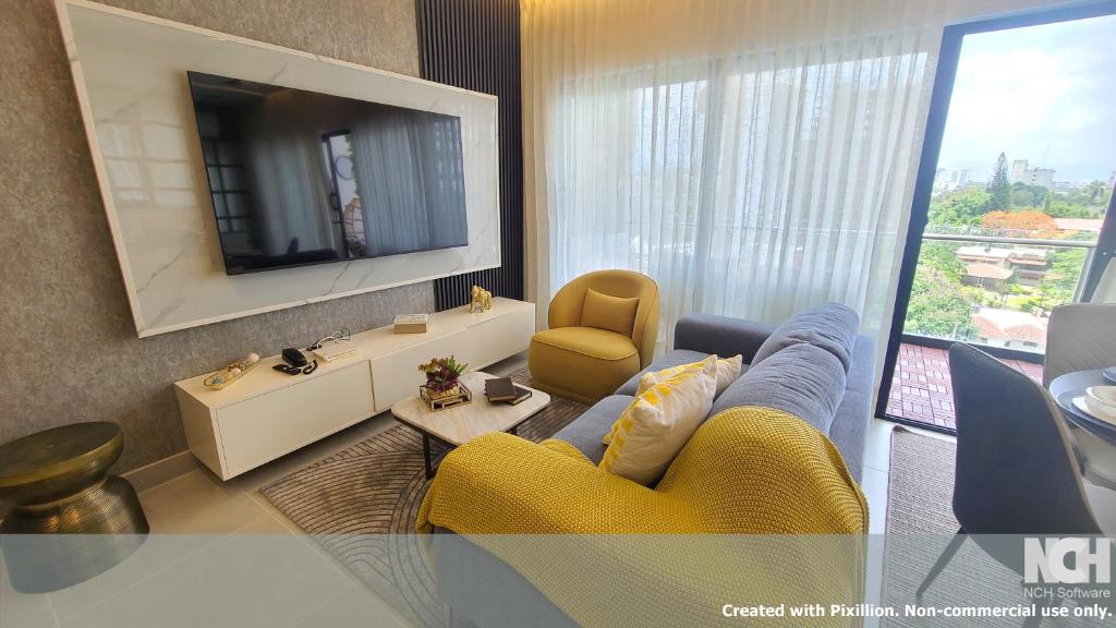 a living room with a yellow couch and a television at Exclusivo céntrico en la Trinitaria in Santiago de los Caballeros
