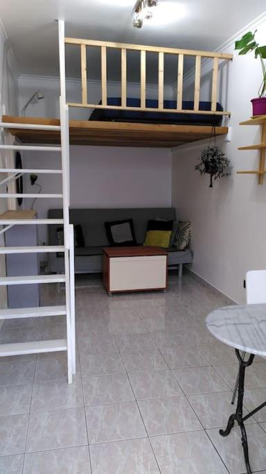 un salon avec un lit superposé et un canapé dans l'établissement Logement calme sur cour, à Arcueil