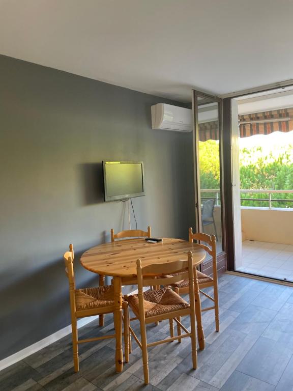 une salle à manger avec une table et des chaises en bois dans l'établissement Frejus plage studio La Miougrano, à Fréjus