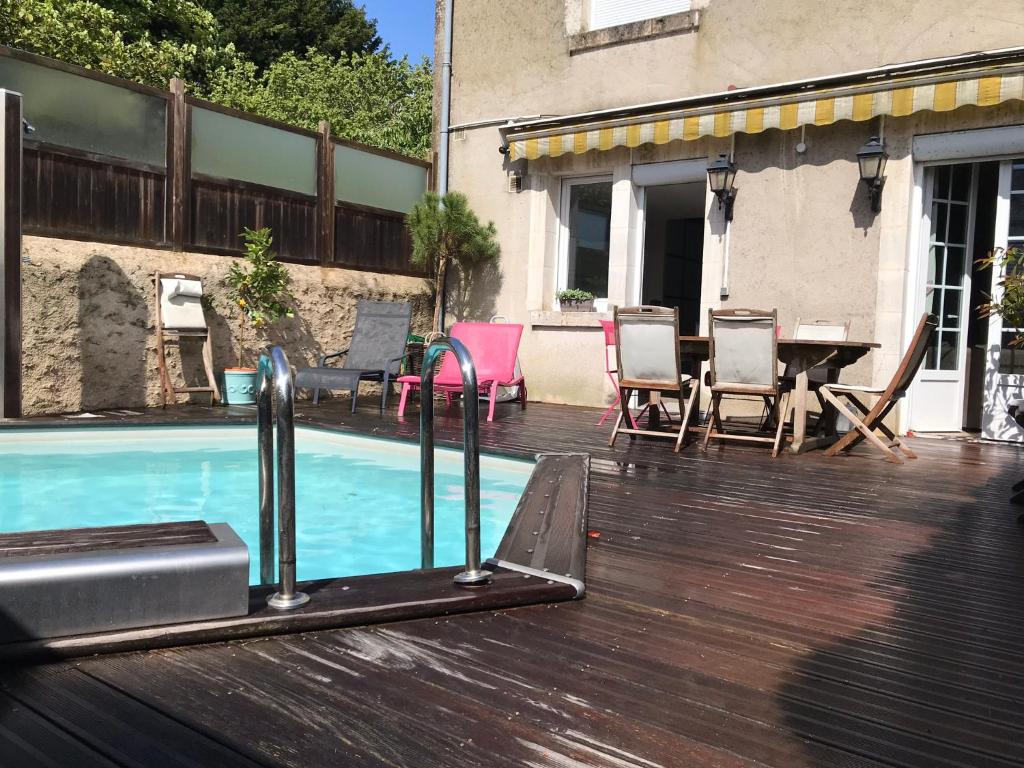 une terrasse avec une piscine avec des chaises et une table dans l'établissement Maison centre ville piscine calme confort, à Blois