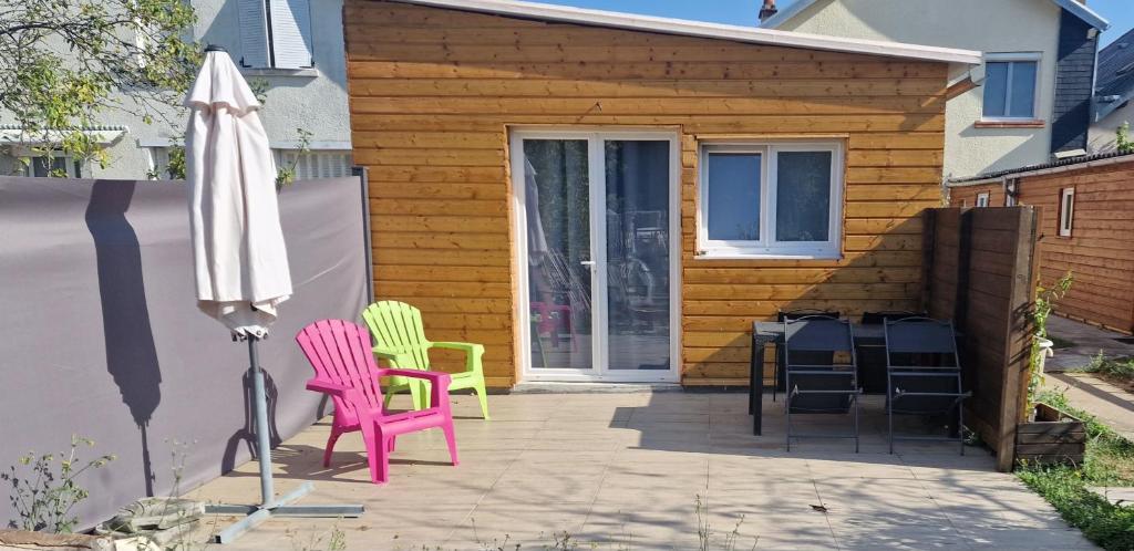 un patio avec deux chaises et un parasol dans l'établissement Studio Renard quartier marais, terrasse en rez de jardin, matelas confort, à Bourges