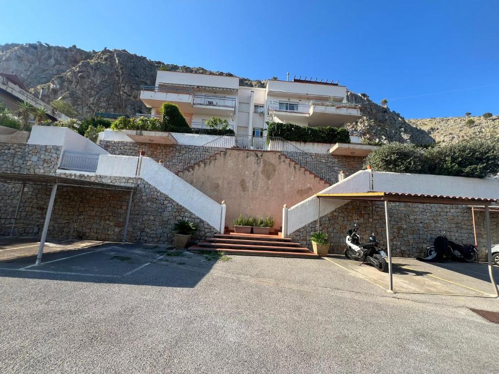 een gebouw met een motor geparkeerd op een parkeerplaats bij Mondello Tolomea guest house in Mondello