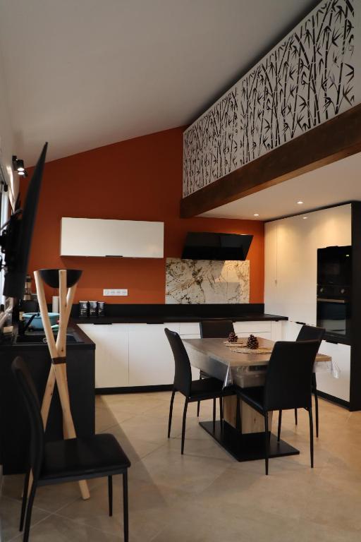 une cuisine et une salle à manger avec une table et des chaises dans l'établissement maison climatisée 150 m de la mer, à Santa-Maria-Poggio