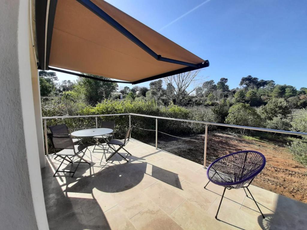 un patio avec une table et des chaises sur un balcon dans l'établissement Studio au calme tout équipé, à Pourrières