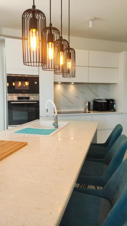 a kitchen with a sink and a counter with chairs at Zavala Residence in Zavala