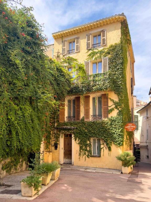 une maison jaune avec du lierre sur son côté dans l'établissement Charming house, à Cannes