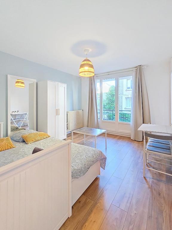 - une grande chambre avec 2 lits et une table dans l'établissement Appartement confortable et calme à Tours centre, à Tours