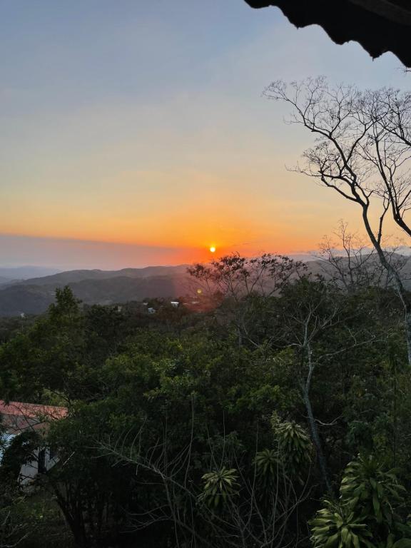 a sunset from the top of a hill with trees at Casa de montaña con vista al océano pacífico in Magallanes