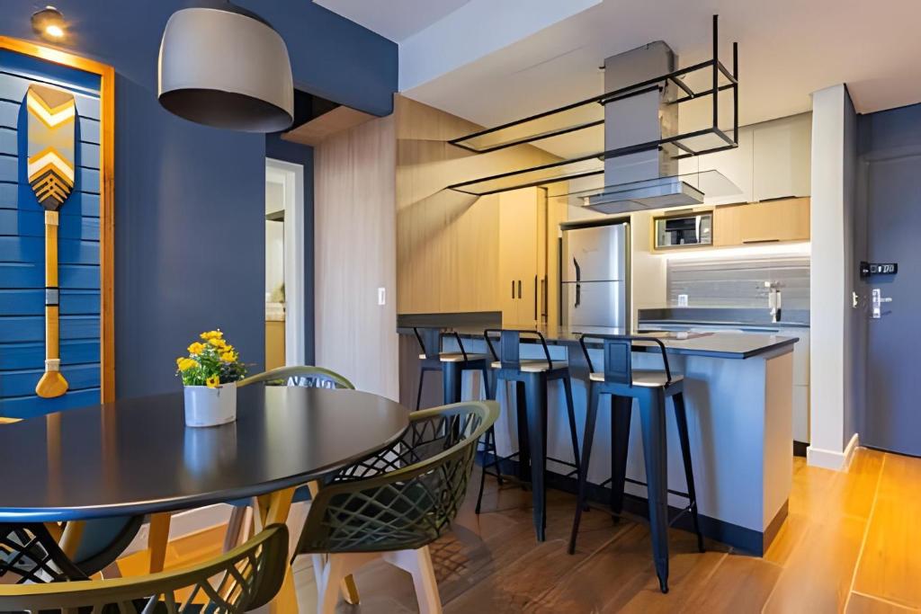una cucina e una sala da pranzo con tavolo e sedie di Apto Super Moderno e Central a Florianópolis