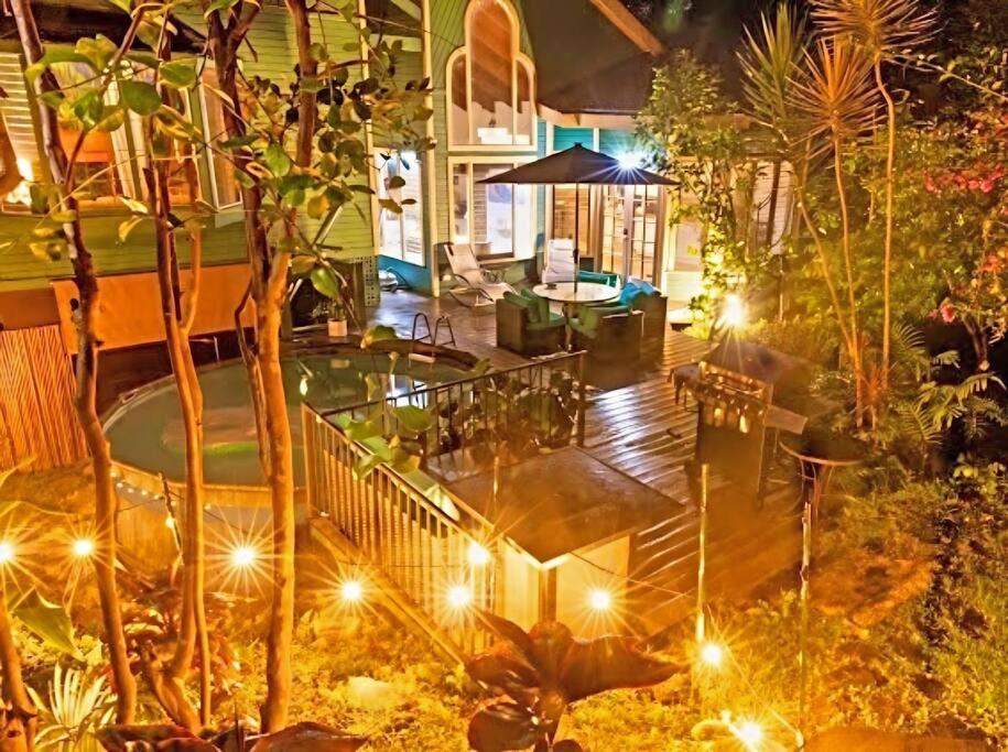a house with a patio at night with lights at Kona Ironman Family Home, Secluded Paradise in Kailua-Kona
