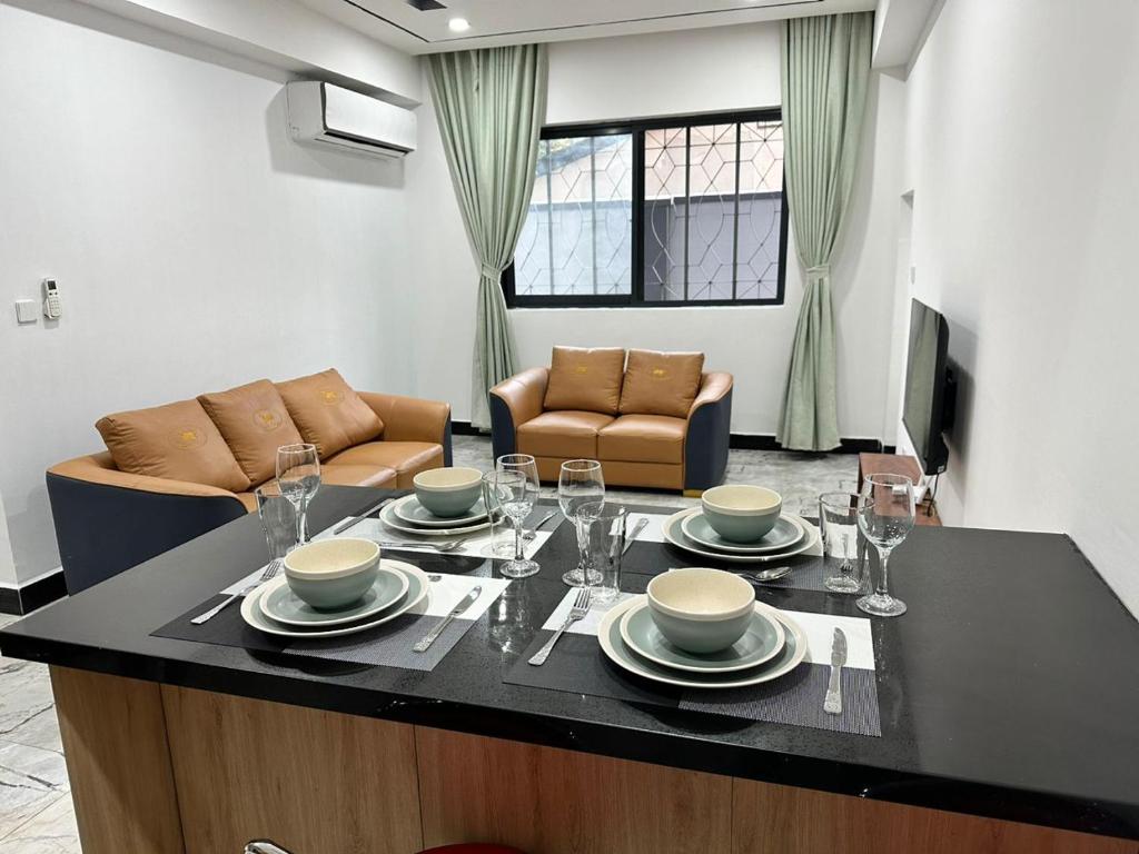 een keuken met een tafel met borden en wijnglazen bij Masaki-2Bedroom-G03 in Dar es Salaam