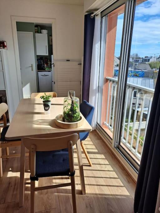 une table et des chaises dans une pièce avec une grande fenêtre dans l'établissement l adresse en Bretagne, à Paimpol