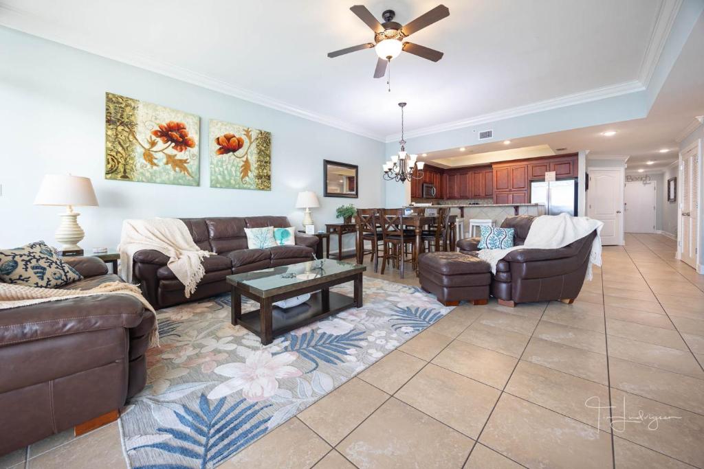 Una sala de estar con sofás y un comedor. en Phoenix Gulf Shores 1602-1 condo, en Gulf Shores