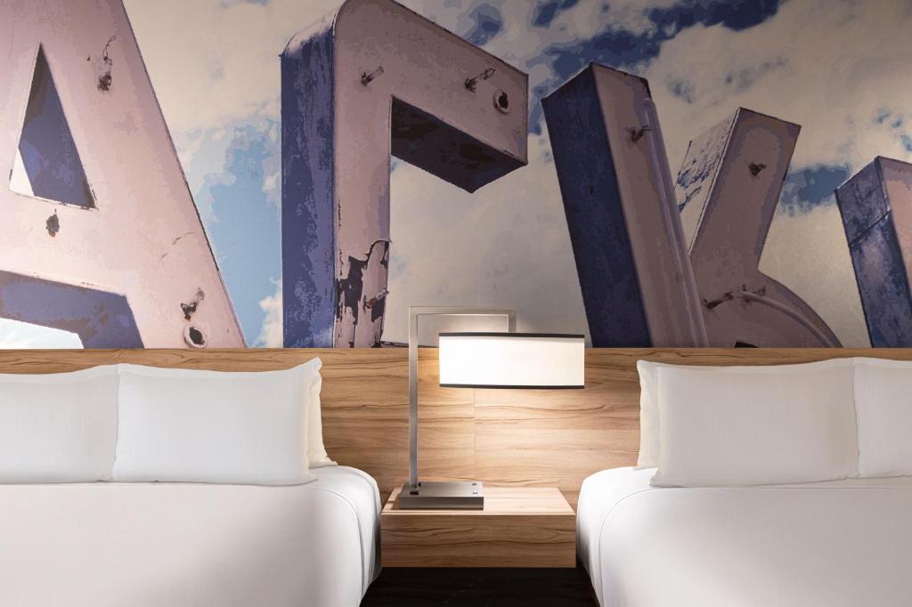 two beds in a room with a mural at The LINQ Hotel and Casino in Las Vegas