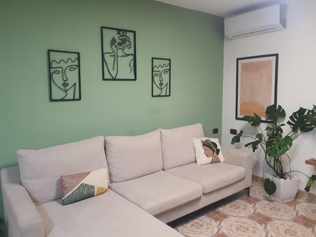 sala de estar con sofá blanco y cuadros en la pared en Central Home Away From Home, en Shkodër