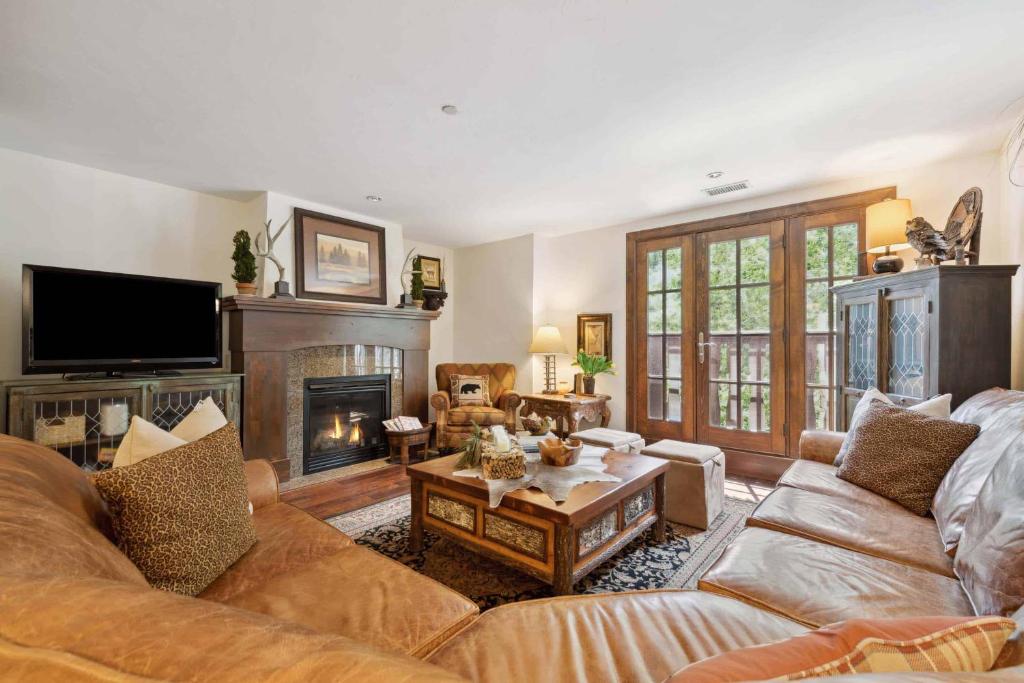 a living room with a couch and a fireplace at Ascent 203 by East West Hospitality in Avon