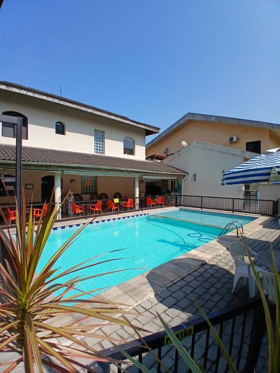une piscine devant un hôtel dans l'établissement Pousada Parque Suites- Estacionamento e Piscina na enseada, à Guarujá