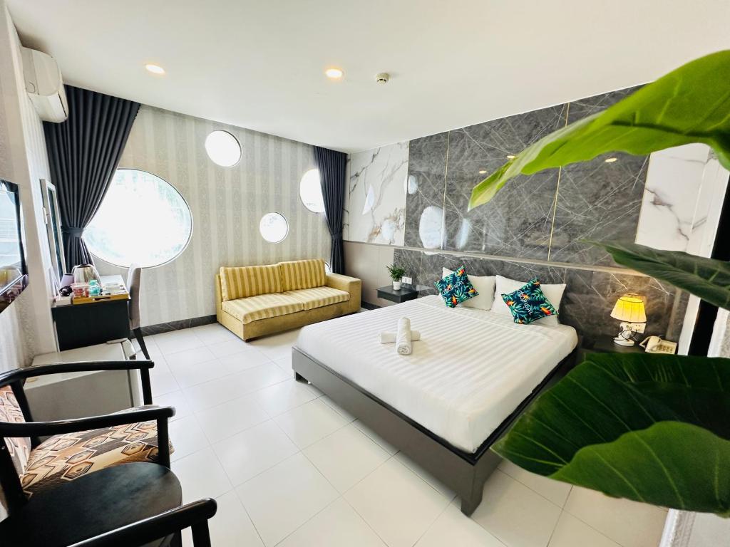 胡志明市Centana Ben Thanh Hotel的房间里有一张床和一张沙发的卧室
