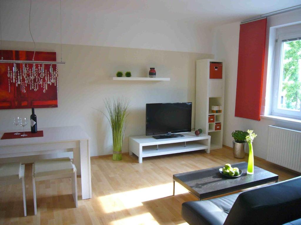 ein Wohnzimmer mit einem Sofa und einem TV in der Unterkunft Apartment Mödling in Mödling