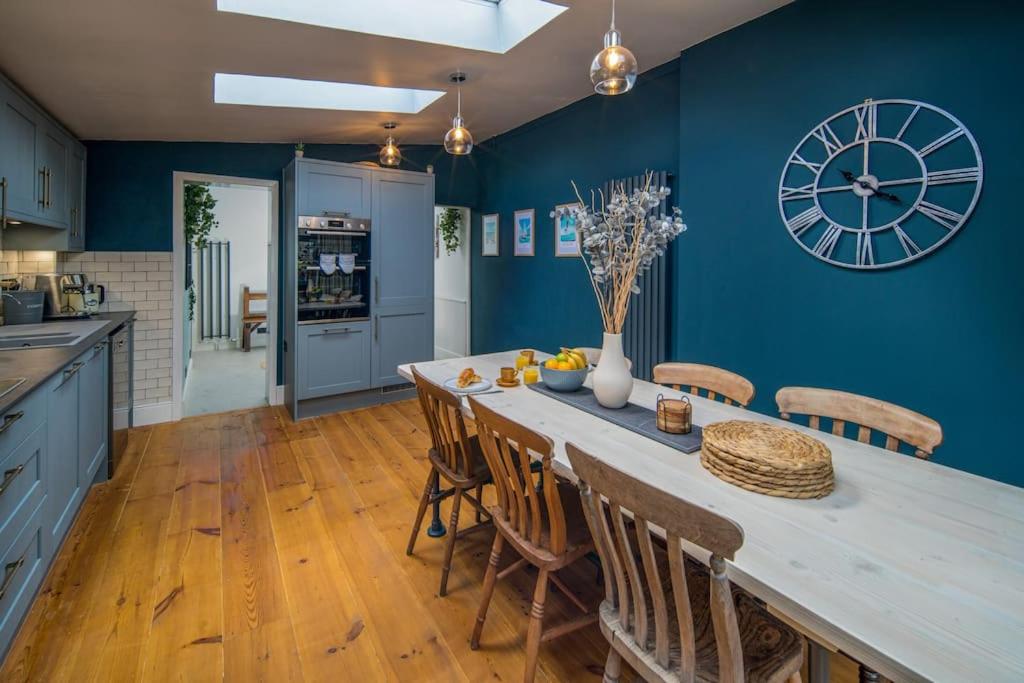 eine Küche mit einem großen Tisch und einer Uhr an der Wand in der Unterkunft Captain's Cottage - Central West Cowes - Spacious, entire 1-bed home in Cowes