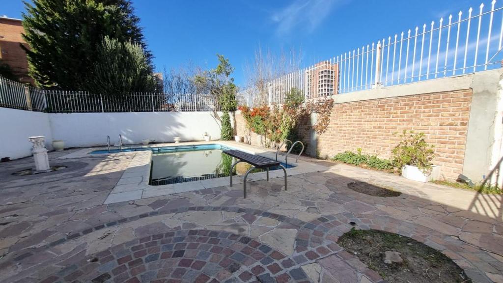a swimming pool in a yard next to a building at Gold House in Neuquén