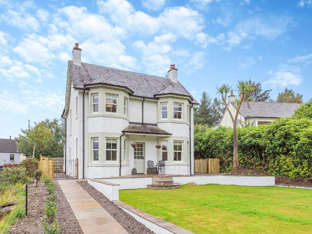 a large white house with a yard with a lawn at Achomraich in Kyle of Lochalsh