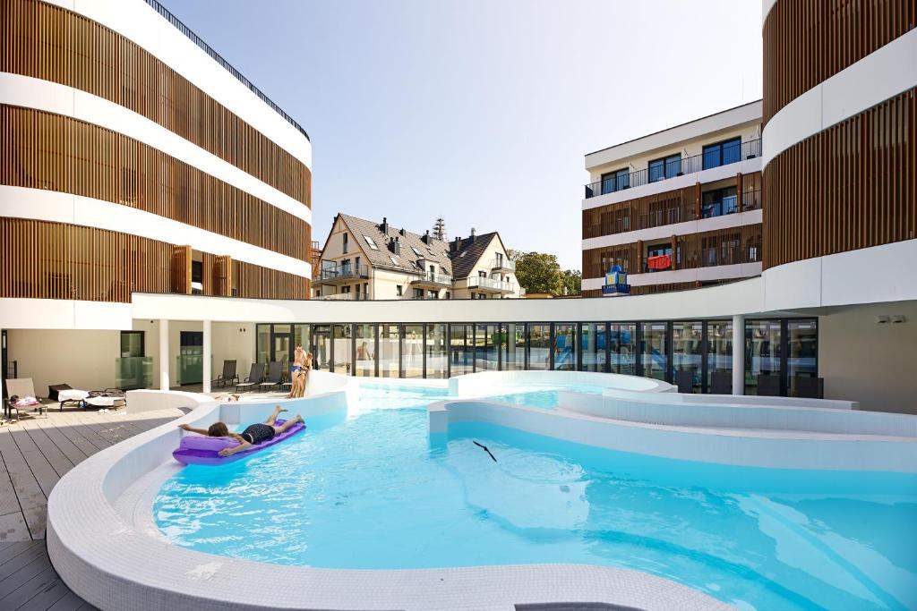 a swimming pool in the middle of a building at Baltic Waves Resort & Wellness I Where the Baltic Meets Luxury in Międzyzdroje