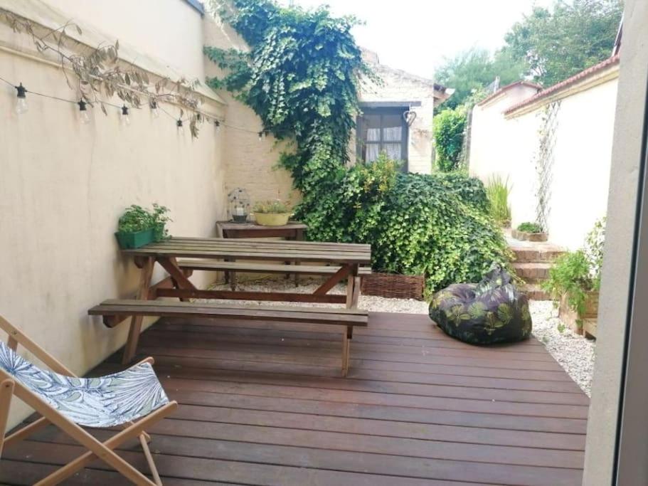 un patio avec deux tables de pique-nique et une chaise dans l'établissement Adorable maison avec jardin - Liévin centre, à Liévin
