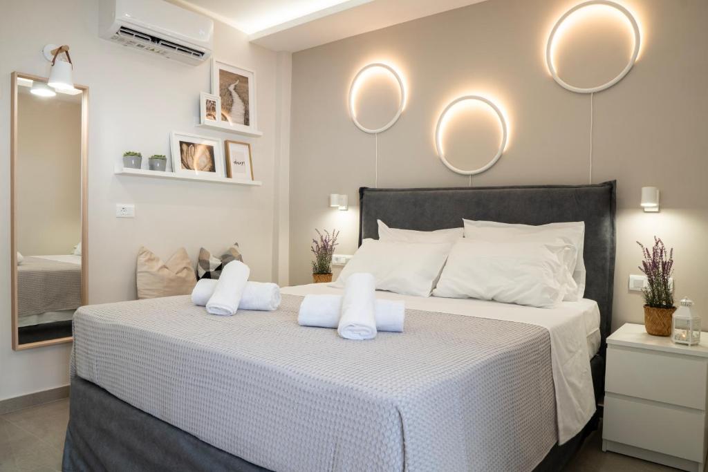 a bedroom with a white bed with two white towels at Armonía Luxury Apartments in Ierápetra