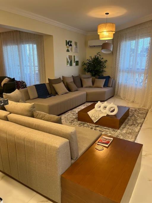 a living room with two couches and a table at Charming apartment In Heliopolis in Cairo