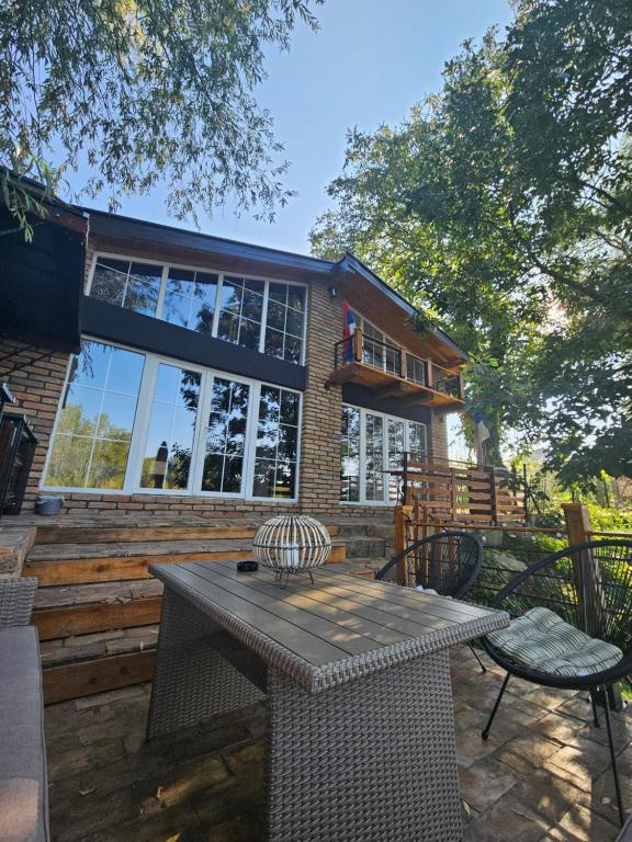 チュプリヤにあるBear Secret Houseの家の前にテーブルと椅子が置かれたパティオ