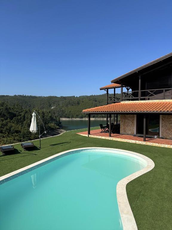 a large swimming pool in front of a house at Lake Prestige Villa Castelo de Bode, Tomar in Tomar