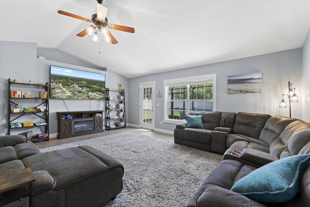 a living room with a couch and a flat screen tv at Wander by the Waves Pet Friendly in Palm Coast