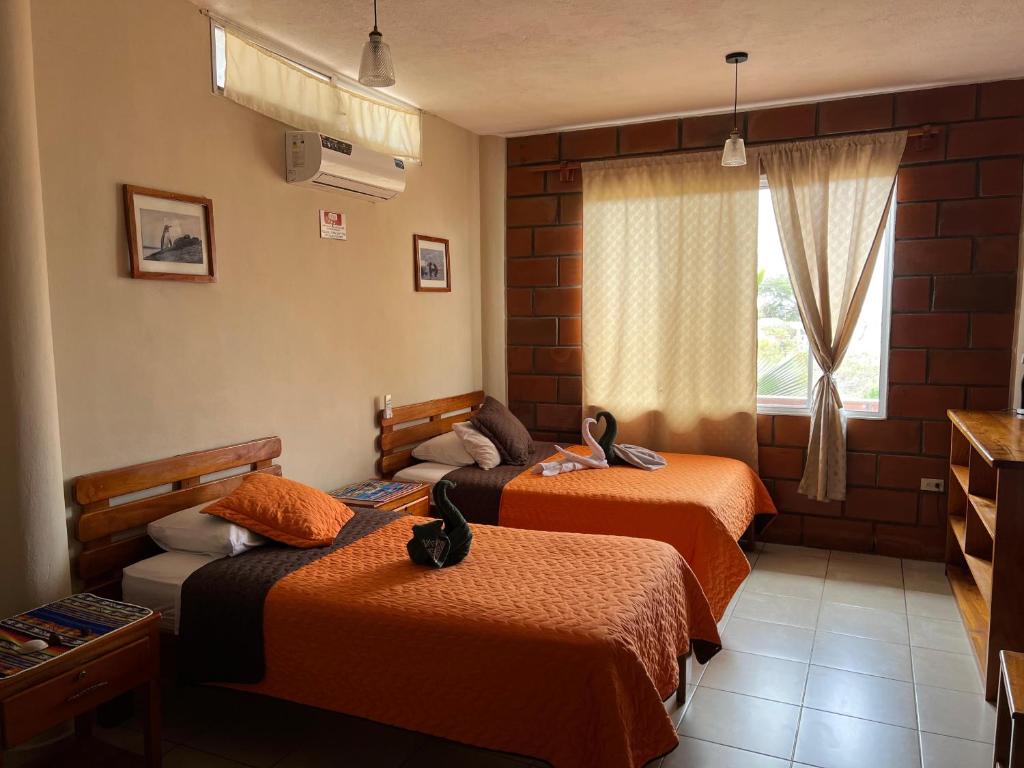 Postel nebo postele na pokoji v ubytování Hostal Cattleya