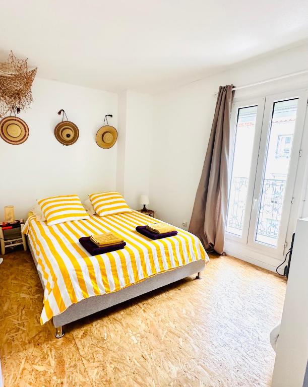 - une chambre avec un lit à rayures jaunes et blanches dans l'établissement Cosy, climatisé, au coeur de Sète, à Sète
