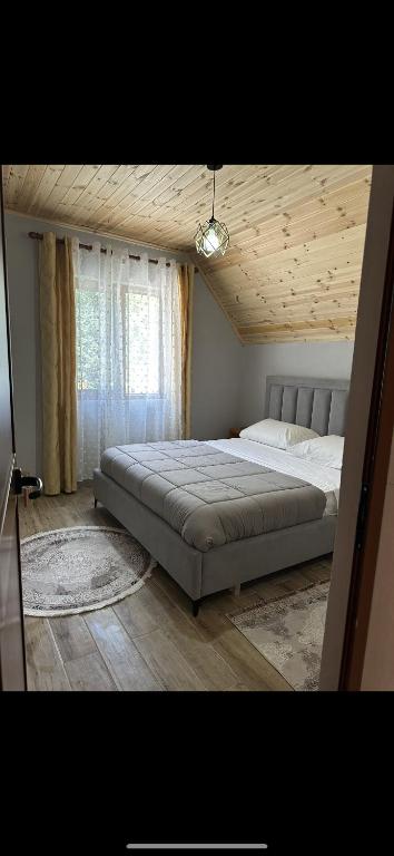 una camera con un grande letto e un soffitto in legno di Bujtina Kometa a Theth
