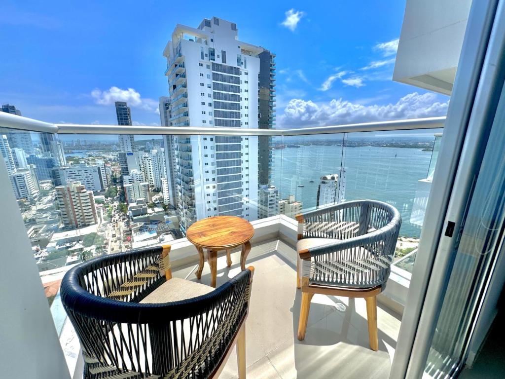 two chairs and a table on a balcony with a view of the city at apto navy 6 tripulantes in Cartagena de Indias
