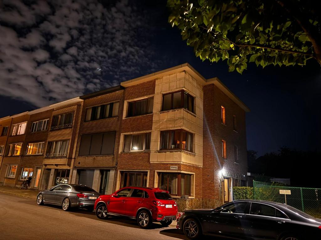 two cars parked in front of a building at night at Charmante appartement in Wilrijk in Antwerp