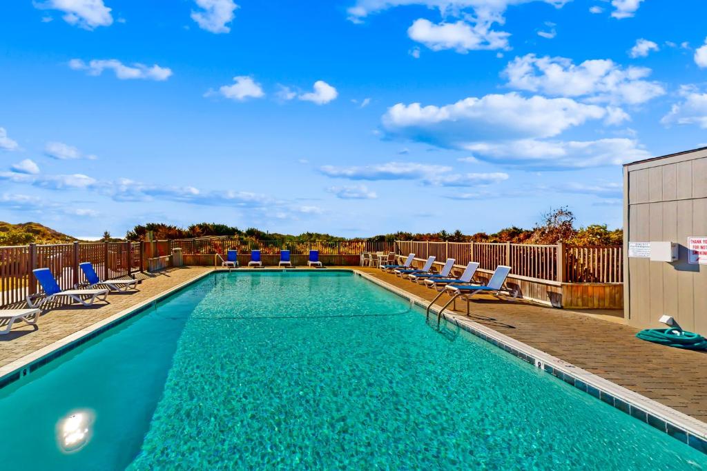a swimming pool with lounge chairs at Southwinds D10 in Atlantic Beach
