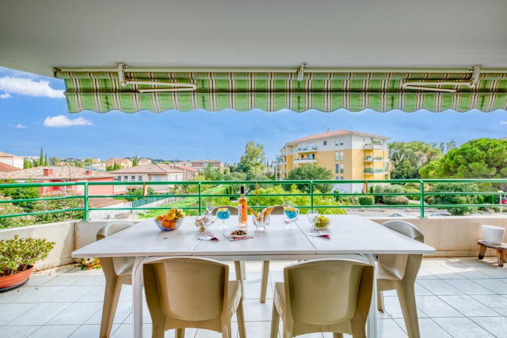 une table blanche et des chaises sur un balcon avec vue dans l'établissement Appartement Le Sambora - Happy Rentals, à Fréjus
