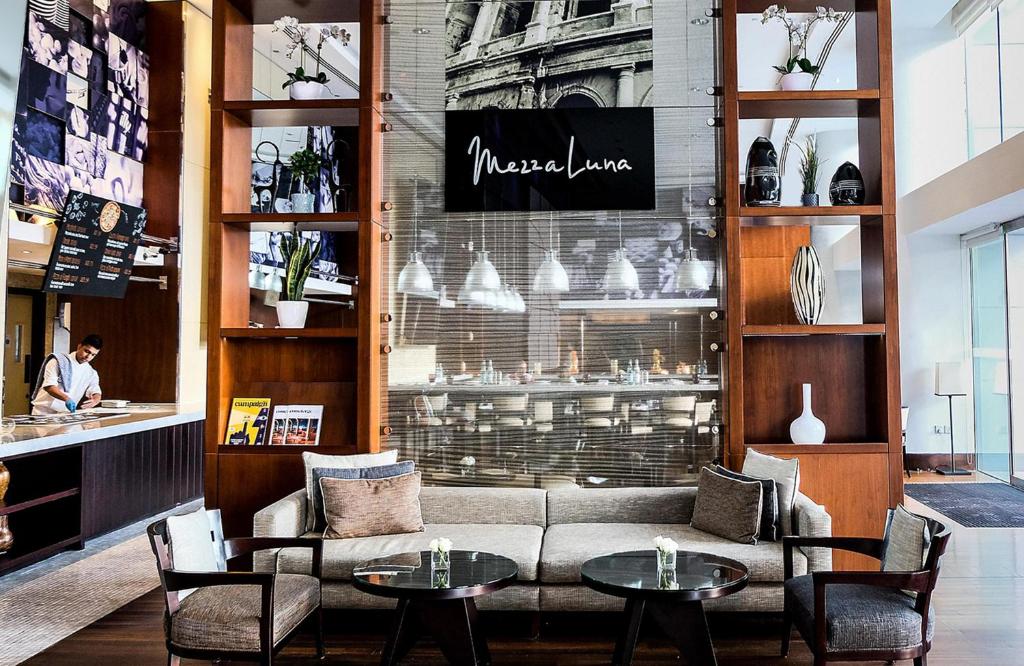 um restaurante com duas mesas e um sofá e cadeiras em InterContinental Residence Suites Dubai Festival City by IHG no Dubai