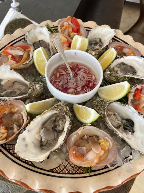 a plate of oysters and a bowl of soup at Villa La Falaise in Oualidia