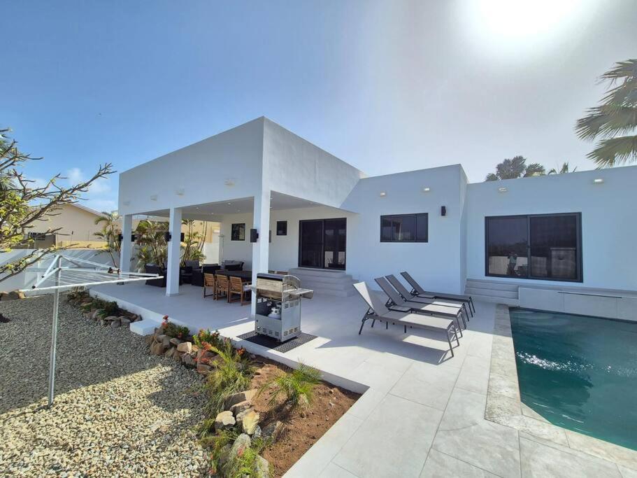 a house with a swimming pool and a patio at Casa Blanca Aruba in Saliña Cerca