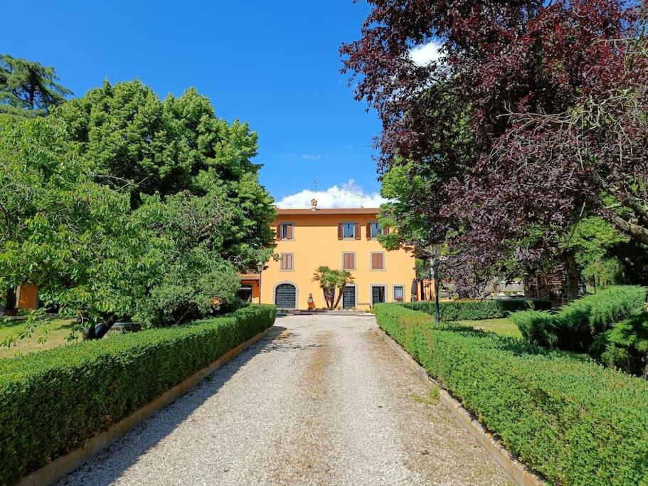 une allée menant à une grande maison jaune dans l'établissement Casale la Quercia - Splendido casale nella natura, à Cura