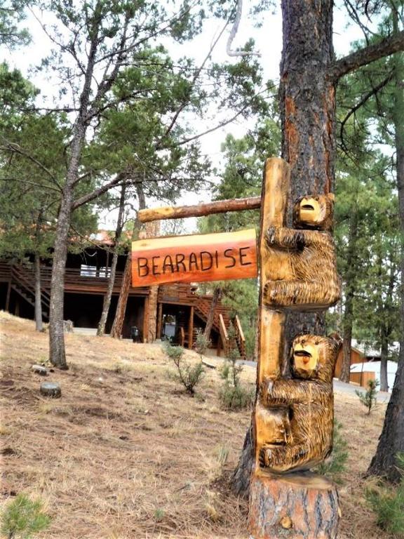 a sign on a pole in front of a building at Bearadise in Ruidoso