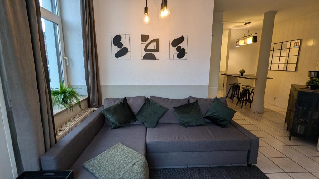WilhelmshöheにあるGemütliche Wohnung mit Parkplatzのリビングルーム(緑の枕とグレーのソファ付)
