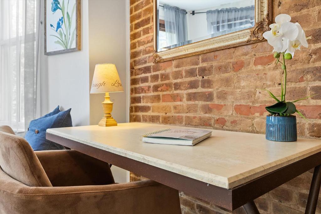 a table with a book and a flower on it at Beautiful 1-BR Flat Nestled Between Dupont & Logan in Washington, D.C.