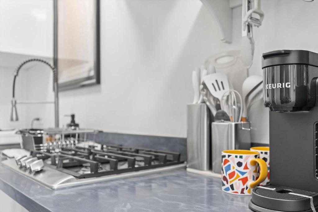 a kitchen counter with a stove and a sink at Beautiful 1-BR Flat Nestled Between Dupont & Logan in Washington, D.C.