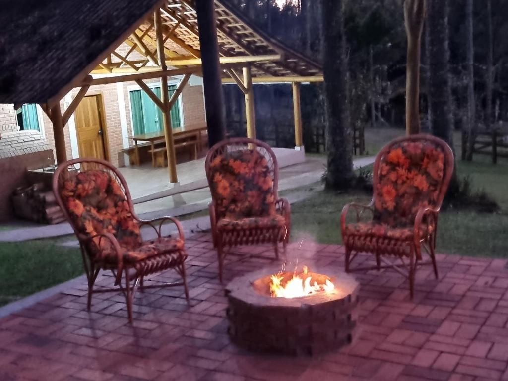 eine Gruppe von Stühlen, die um eine Feuerstelle herum sitzen in der Unterkunft Casa de campo Campo Alegre SC 11 Hóspedes in Campo Alegre