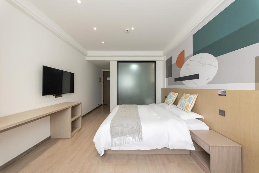 a bedroom with a bed and a flat screen tv at 乌镇闲情逸致精品民宿 in Wujiaqiao